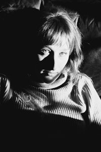 a black and white photo of a woman laying on a couch