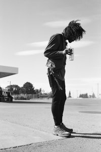 a black and white photo of a man with dreadlocks